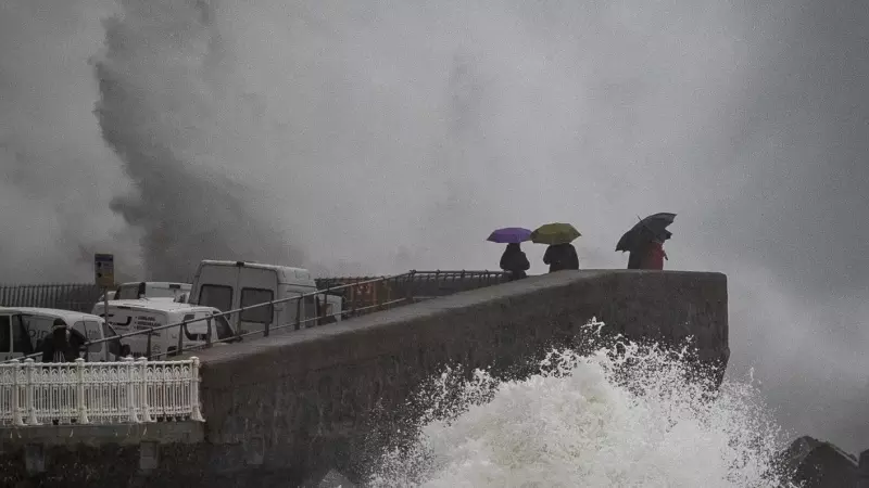 Varias personas observan el oleaje en el Paseo Nuevo de San Sebastián, donde se ha decretado la alerta naranja por impacto de olas en la costa, a raíz del temporal, a 17/01/2023