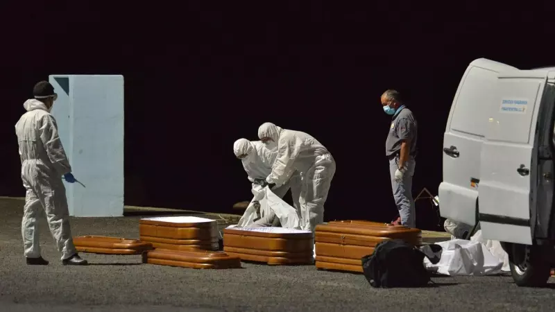 Varios trabajadores introducen en un ataúd a una persona fallecida en alta mar tras intentar llegar a la costa a bordo de una patera, a 11 de abril de 2021, en el puerto de la Restinga, Canarias.