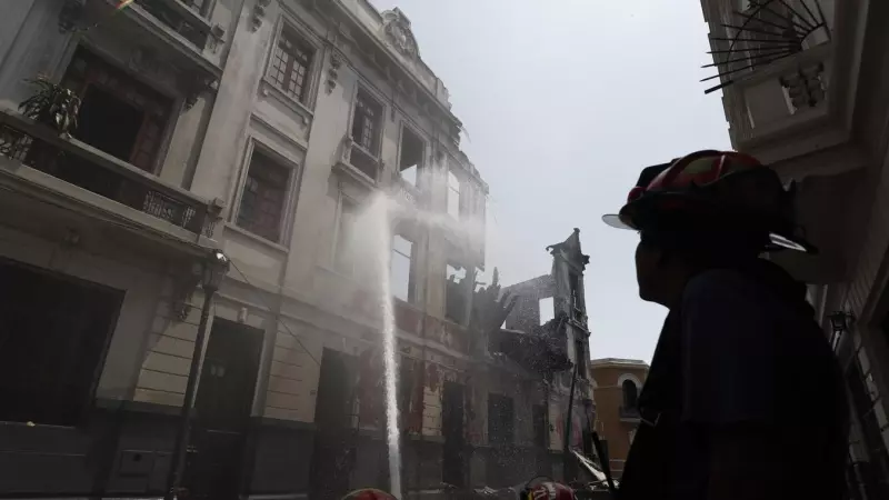 Bomberos trabajan en los alrededores de una casona que se incendió ayer durante la jornada de protestas en Lima.