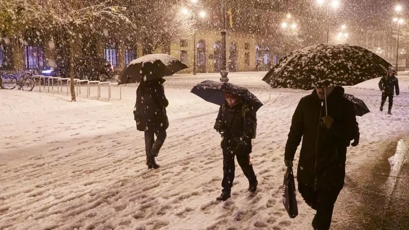 Varias personas caminan por una calle nevada, a 19 de enero de 2023, en Pamplona, Navarra.