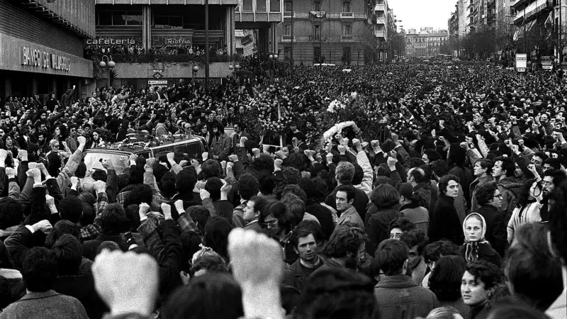 Miles de personas se congregan el 26 de enero de 1977 ante el paso del cortejo fúnebre de los asesinados en el despacho de los abogados laboralistas de la madrileña calle de Atocha.