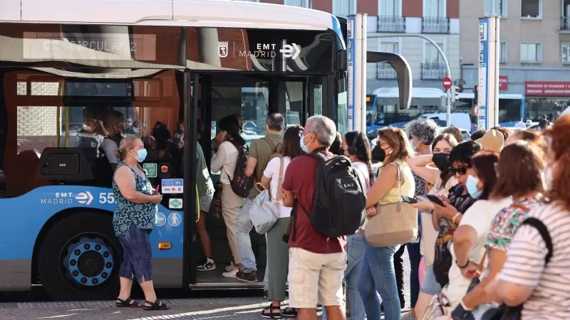 Varias personas, con mascarilla, hacen cola para subir a un autobús de la Empresa Municipal de Transportes madrileña (EMT), a 1 de septiembre de 2022, en Madrid (España).
