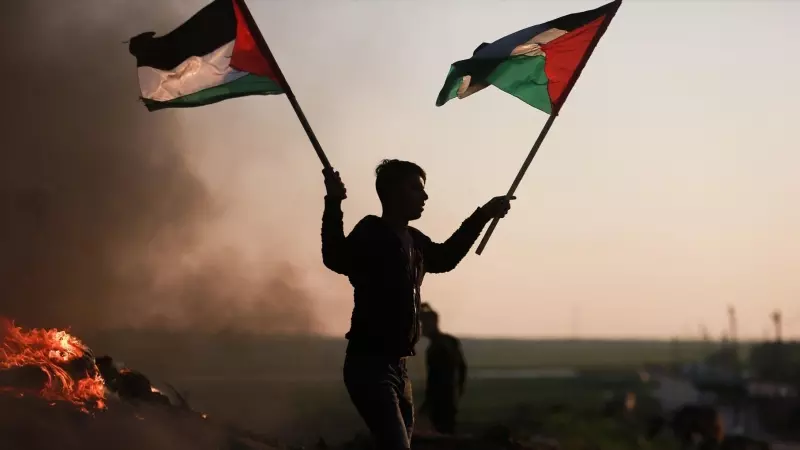 Un manifestante con la bandera de Palestina en la frontera de Gaza protesta tras los últimos ataques contra un campamento de refugiados en Yenín.