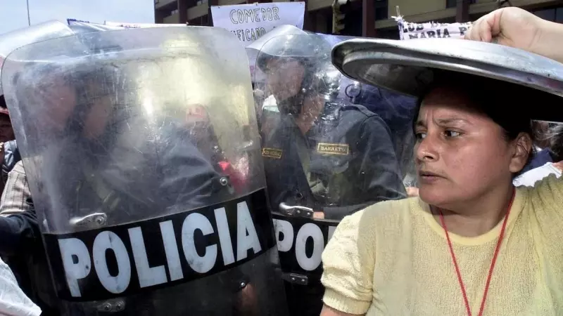 Una mujer de la organización popular Madres del Vaso de Leche se cubre la cabeza con la tapa de una olla el 27 de noviembre de 2003 en las puertas del Congreso en Lima.