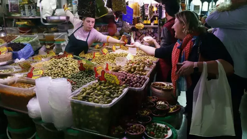Una señora compra aceituna en el Mercados de Abastos de Málaga antes de la Navidad, a 23 de diciembre de 2022.