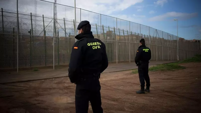 Imagen de archivo de dos agentes de la Guardia Civil junto a la valla de Melilla.