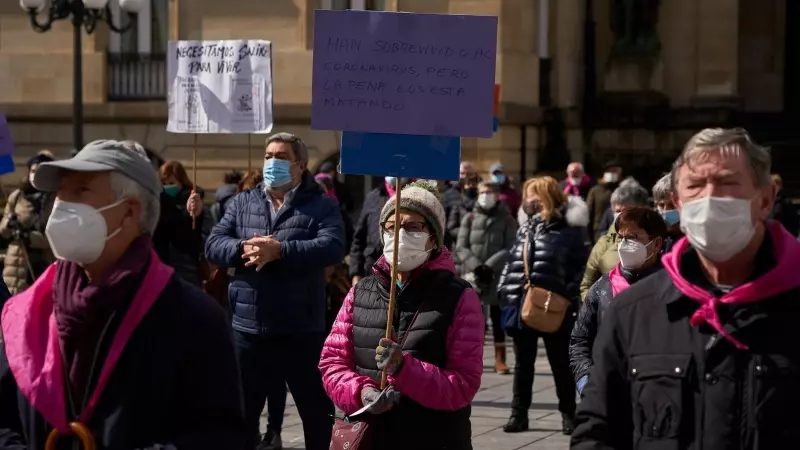 Varias personas con carteles en una manifestación en homenaje a los residentes fallecidos por coronavirus en la Plaza de la Diputación de Vitoria, País Vasco (España), a 20 de marzo de 2021.