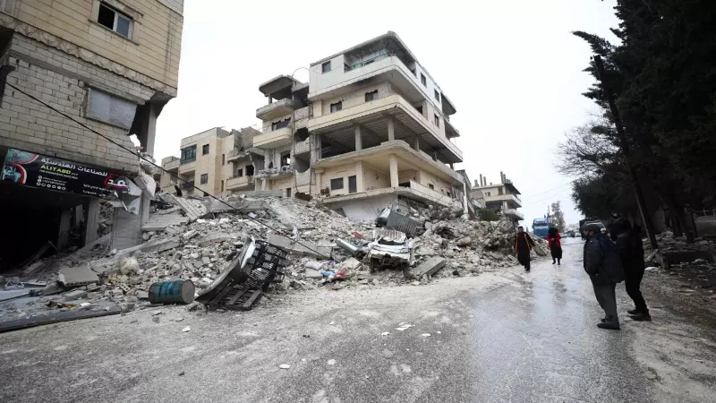 Gente camina al lado de varios edificios derrumbados por el terremoto en la ciudad de Armanaz, en el distrito de Idlib (Siria) este 6 de febrero de 2023.