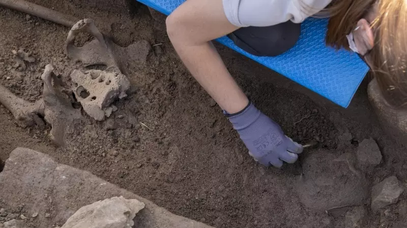Imagen de archivo de una antropóloga limpiando restos de cuerpo humano en el yacimiento visigodo de El Rebollar, en Madrid, a 21 de mayo de 2021.