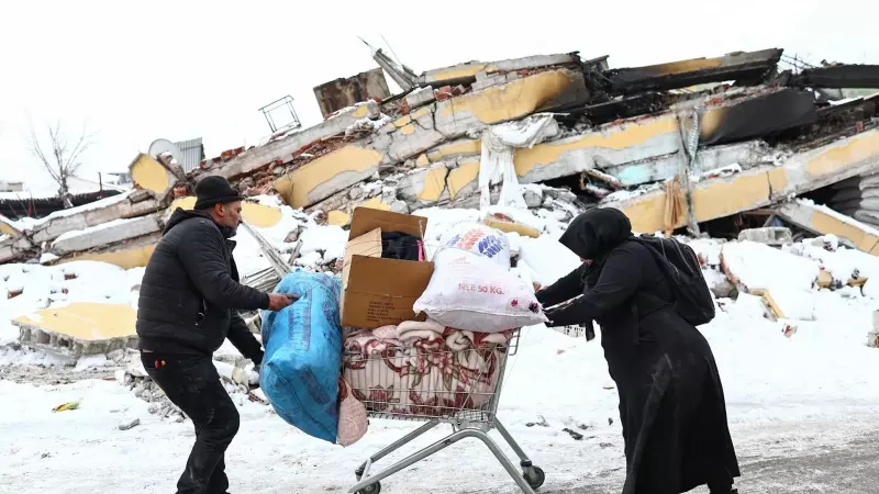 Dos personas transportan en un carrito de la compra sus enseres tras quedarse sin casa debido al terremoto en Kahramanmaras (Turquía) este 8 de febrero de 2023.