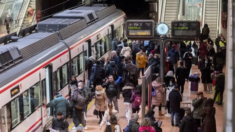 Imagen de archivo de varias personas en el andén de Cercanías en la estación de Atocha (Madrid) esperando la llegada de los trenes.