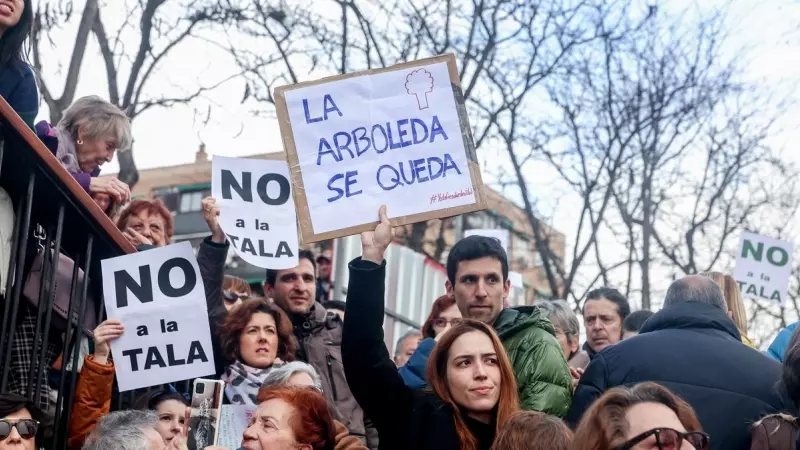 Una mujer porta una pancarta que reza 'La arboleda se queda' en la concentración para defender la arboleda de la zona de Madrid Río, que se verá afectada por las obras del Metro, a 18 de febrero de 2023, en Madrid (España).