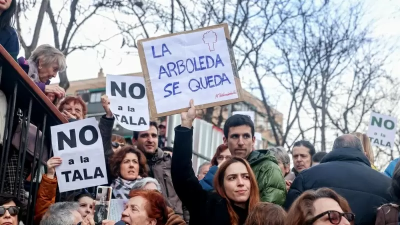 Una mujer porta una pancarta que reza 'La arboleda se queda' en la concentración para defender la arboleda de la zona de Madrid Río, que se verá afectada por las obras del Metro, a 18 de febrero de 2023, en Madrid (España).
