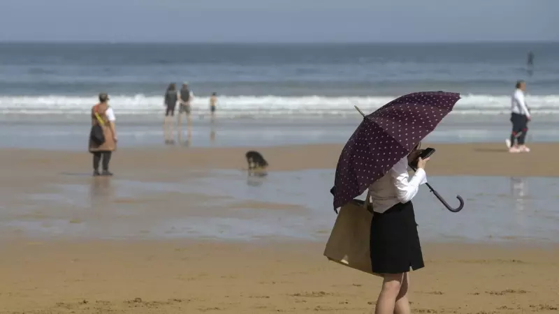 Playa de San Lorenzo de Gijón, este domingo, con las temperaturas en ascenso en todo el país.