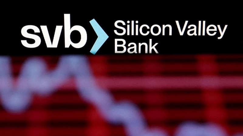 El logotipo de SVB (Silicon Valley Bank) y el gráfico de acciones decrecientes tomada el 19 de marzo de 2023.