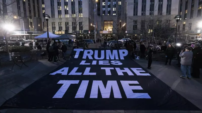 Ciudadanos despliegan un cartel en el que se lee en inglés 'Trump miente todo el tiempo' frente la Corte Penal de Nueva York tras la imputación de Tump.