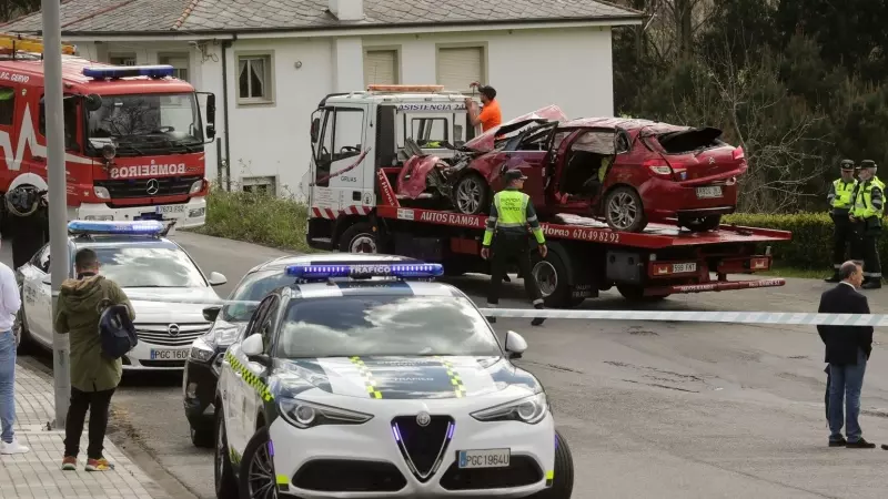 Un Guardia Civil vigila la retirada del coche siniestrado, en el accidente, por una grúa, a 1 de abril de 2023, en Xove (Lugo).