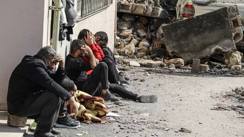Varias personas lloran la muerte de sus seres queridos tras el devastador terremoto y sus réplicas a lo largo de la frontera turco-siria el pasado febrero.