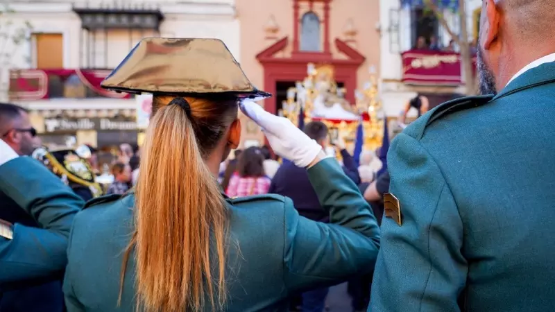 Una agente de la Guardia Civil saluda la salida del paso de La Piedad de la Hermandad del Baratillo, en Sevilla. E.P./Eduardo Briones