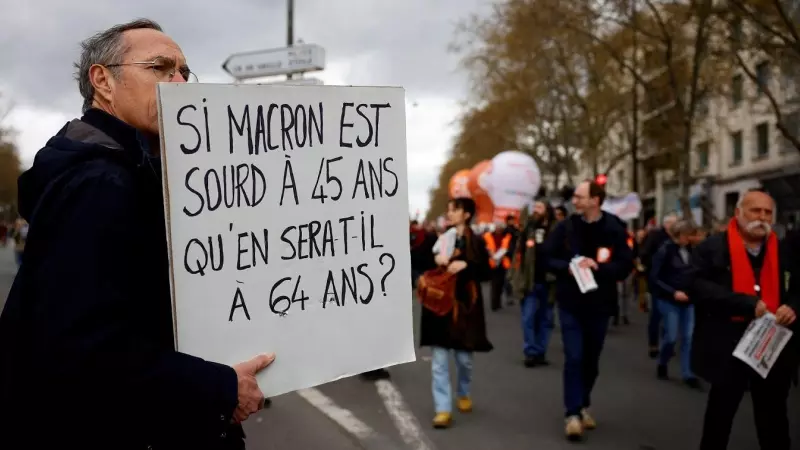 Un manifestante sostiene una pancarta contra la elevación de la edad de jubilación a los 64 años ('Sí Macron está sordo a los 45 años, ¿cómo estará a los 64?', dice), en París, en la nueva jornada de protestas, la úndécima, contra el proyecto del presiden