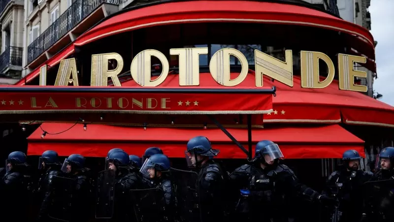 Gendarmes franceses antidisturbios agrupados delante del restaurante 'La Rotonde' de París, durante la nueva jornada de protestas, la undécima, contra la reforma de las pensiones y la elevación de la edad de jubilación a los 64 años aprobada por el presid