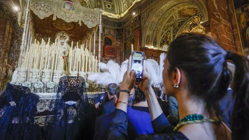 Una joven fotografía el paso de Semana Santa de la virgen de la Macarena en la Basílica de La Macarena, en Sevilla, horas antes de que salga en procesión en la tradicional 'Madrugá'. EFE/Jose Manuel Vidal