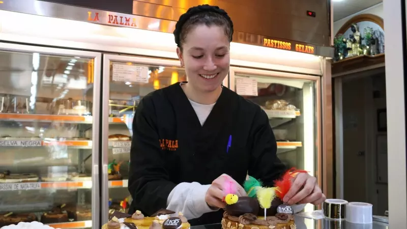 Una de les dependentes de la pastisseria La Palma decorant una mona de Pasqua