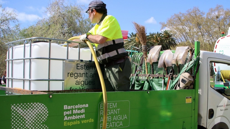 Un operari omple un dipòsit amb aigua freàtica provinent del camió cisterna al Parc de la Ciutadella de Barcelona.