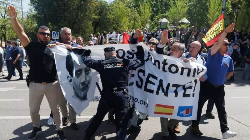 Un agente de Policía Nacional paraliza a varios simpatizantes de la Falange, en el cementerio sacramental de San Isidro, a 24 de abril de 2023, en Madrid.