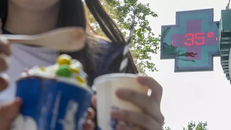 Unas personas se refrescan con helados en Zaragoza este jueves.