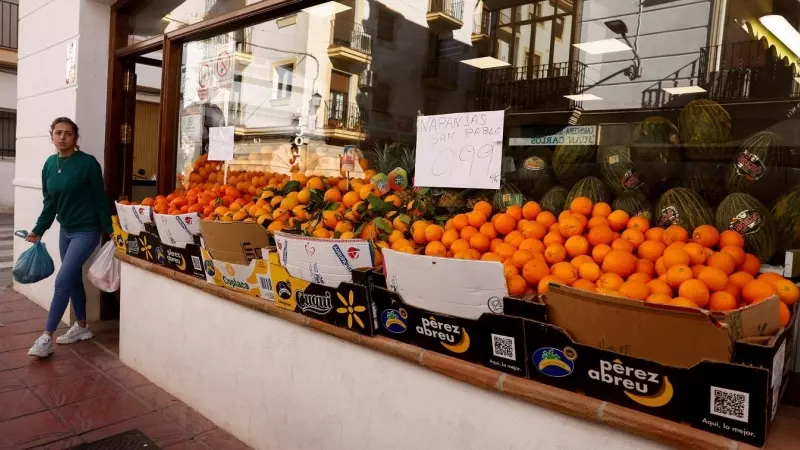 Una mujer sal de comprar en una frutería en la localidad malagueña de Ronda. REUTERS/Jon Nazca