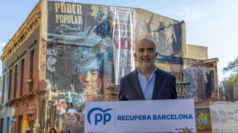 El candidat del PPC a l'Ajuntament de Barcelona, Daniel Sirera, amb el seu lema de campanya front a la icònica casa ocupada de Sant, Can Vies.