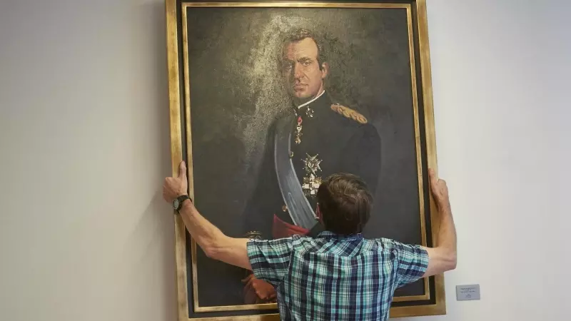 Un operario retira el retrato del rey emérito Juan Carlos I en la Sala de Gobierno del Parlamento de Navarra