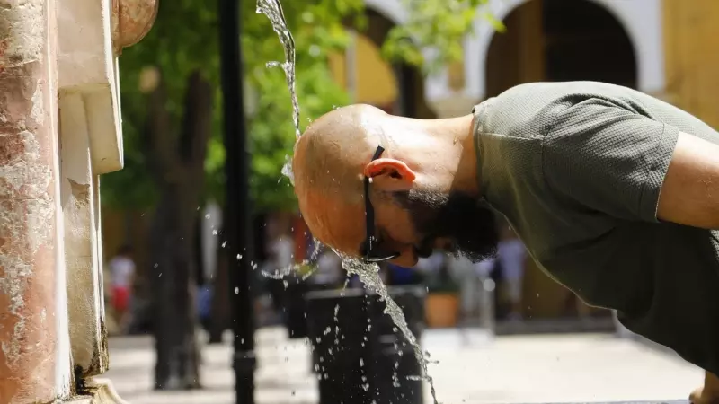 Un hombre se refresca la cabeza en una fuente del Patio de los Naranjos de la Mezquita-Catedral de Córdoba.