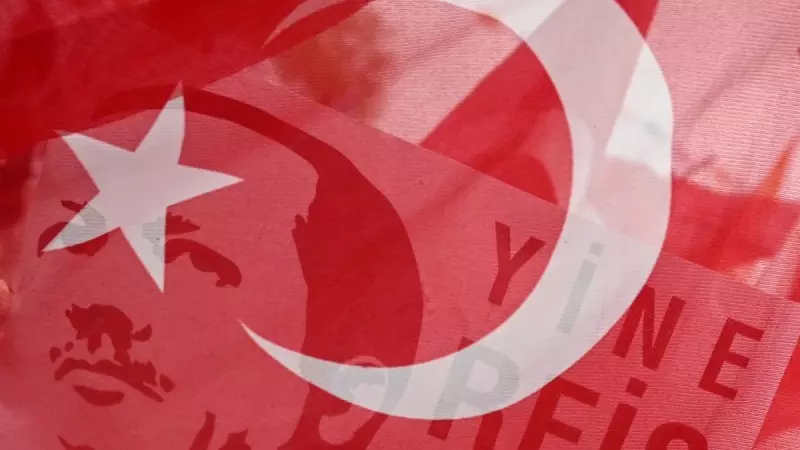 Un cartel del presidente turco, Recep Tayyip Erdogan, visto a través de una bandera nacional, en una imagen tomada antes de un mitin de campaña del mandatario en el distrito Sultangazi de Estambul