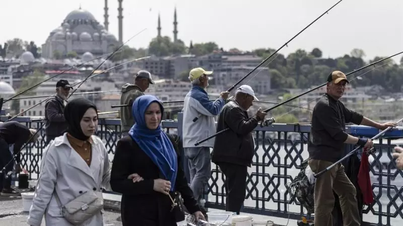 16/5/23 Varias personas en el puente de Galata, con la mezquita de Suleimán al fondo, ayer en Estambul.