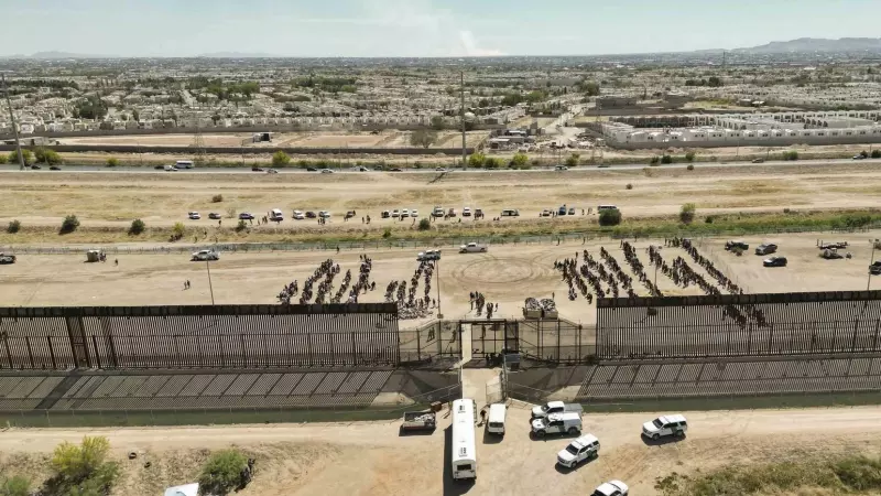 Fotografía aérea muestra hoy a cientos de migrantes mientras esperan junto al muro fronterizo en El Paso, Texas (EE.UU)