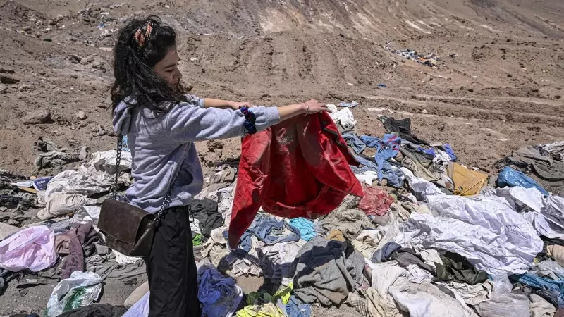 Una mujer examina las prendas abandonadas en el desierto de Atacama, en Chile, a 15 de noviembre de 2022.