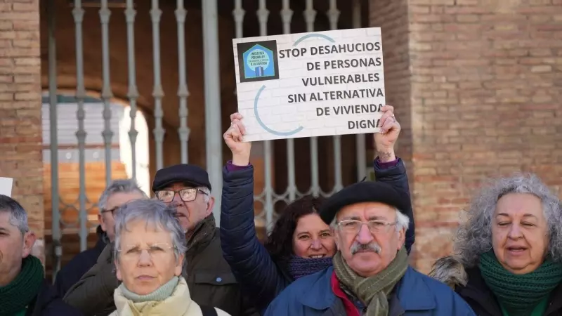 Una mujer levanta una pancarta de 'Stop desahucios' durante una concentración de la Plataforma de Afectados por la Hipoteca (PAH) .