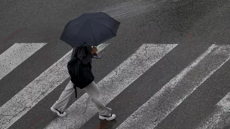 Un persona se protege de la lluvia con un paraguas cuando la semana comienza en País Valencià con el cielo nuboso en la mitad sur, a 22 de mayo de 2023.