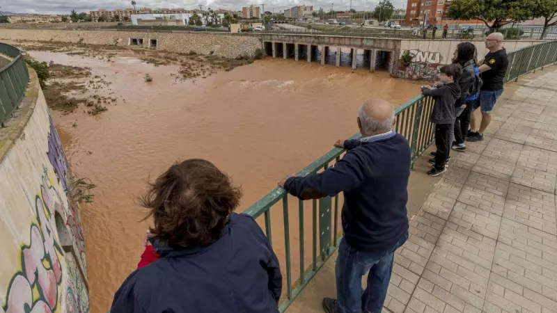 Varias personas observan la rambla de Benipila de Cartagena este martes tras las fuertes lluvias que han caido en las últimas horas en la comarca de Cartagena. EFE/Marcial Guillén