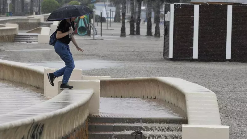 Una persona camina bajo la lluvia en el Paseo Marítimo de Aguadulce, en Roquetas de Mar ( Almería)EFE / Carlos Barba