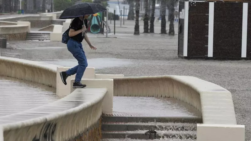 Una persona camina bajo la lluvia en el Paseo Marítimo de Aguadulce, en Roquetas de Mar ( Almería)EFE / Carlos Barba