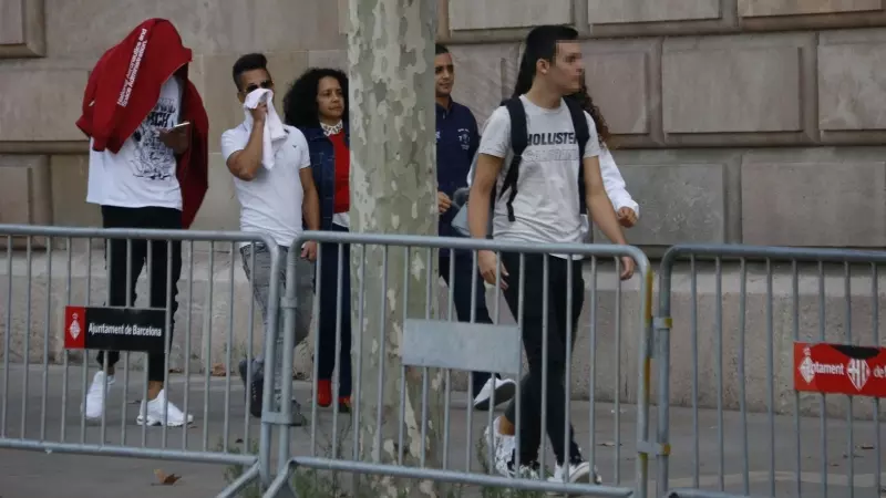 Pla general de tres dels acusats, acompanyats d'una familiar, arribant a l'Audiència de Barcelona, al setembre del 2019