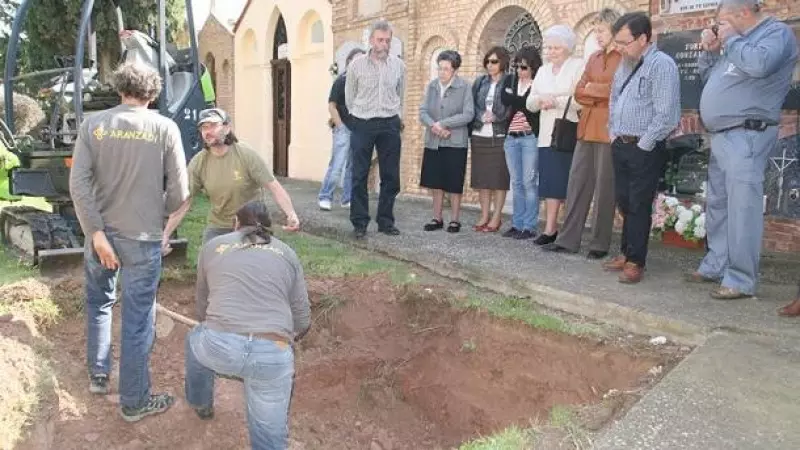 Un grupo de personas, frente a una zanja abierta en el cementerio de Alfaro (La Rioja)