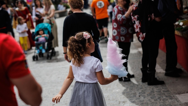 Una niña con un algodón de azúcar en el mercadillo, de la Feria Medieval de El Álamo, a 30 de abril de 2022