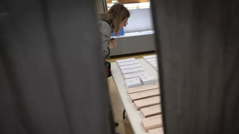 Una mujer observa las papeletas en la jornada electoral del 28M.