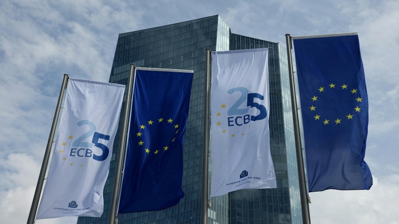 Bandera de la UE y banderolas con el logo conmemorativo del 25 aniversario del BCE, de su sede en Fráncfort. — Daniel Roland / AFP