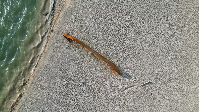 Una canoa en el suelo agrietado de un embalse afectado por la sequía.