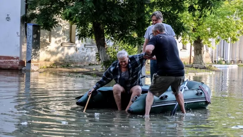 06/06/2023 - Dos personas ayudan a un anciano a subirse a un bote inflable mientras evacua de su casa en una calle inundada de Kherson, Ucrania, a 6 de junio de 2023.